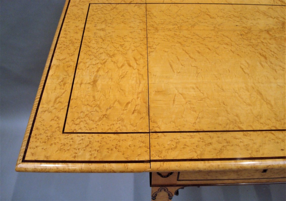A nineteenth-century French birds eye maple sofa table featuring drop-leaf ends, twin drawers, Gothic Revival spandrels, and a low stretcher with trefoil inlay. View XIV