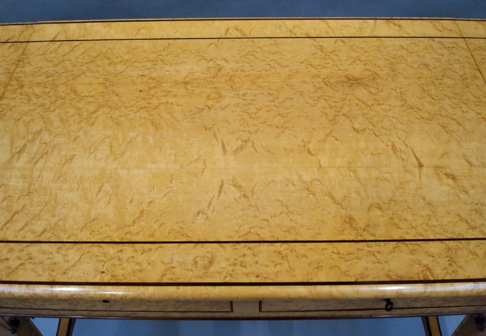 A nineteenth-century French birds eye maple sofa table featuring drop-leaf ends, twin drawers, Gothic Revival spandrels, and a low stretcher with trefoil inlay. View XV