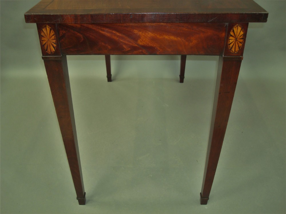 A George III mahogany side table featuring a rectangular top, flame mahogany frieze, patera marquetry corner inlays, and square tapered legs. View III