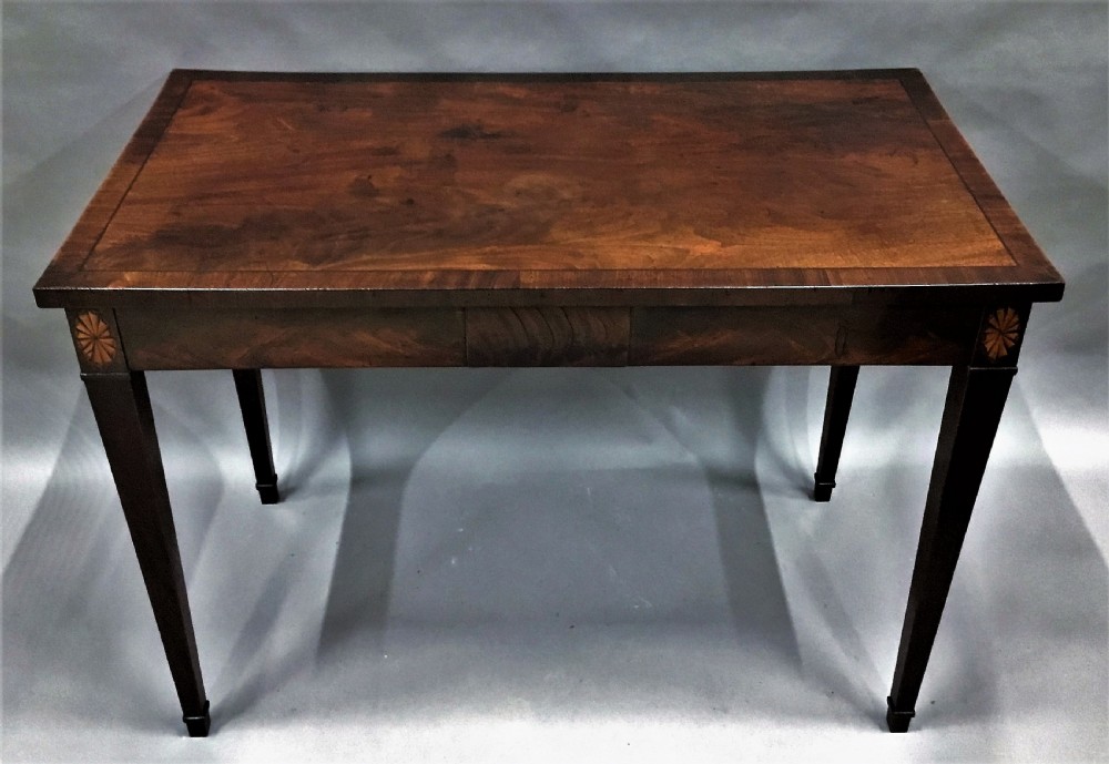 A George III mahogany side table featuring a rectangular top, flame mahogany frieze, patera marquetry corner inlays, and square tapered legs. View XI
