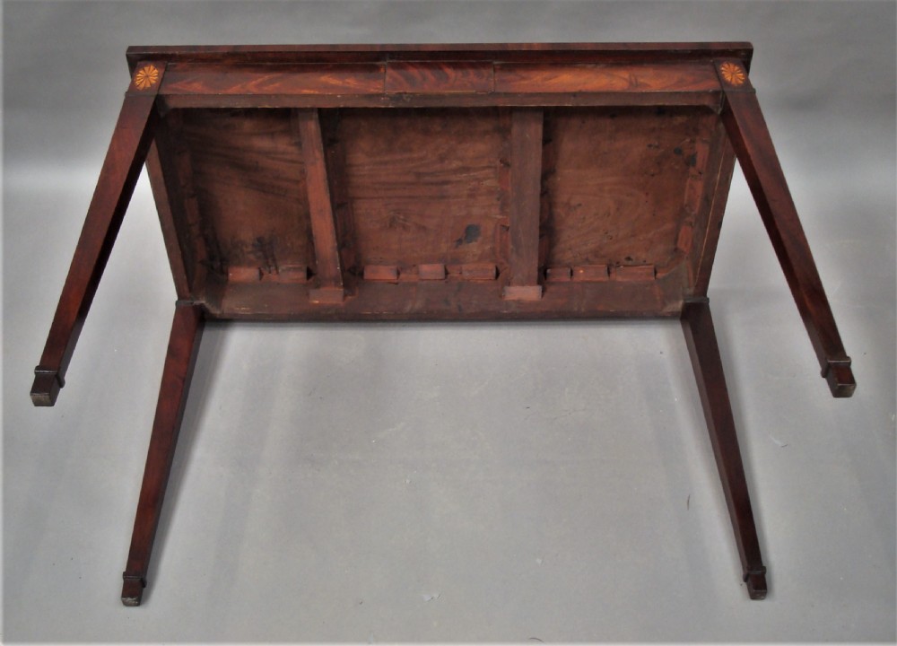 A George III mahogany side table featuring a rectangular top, flame mahogany frieze, patera marquetry corner inlays, and square tapered legs. View XIV