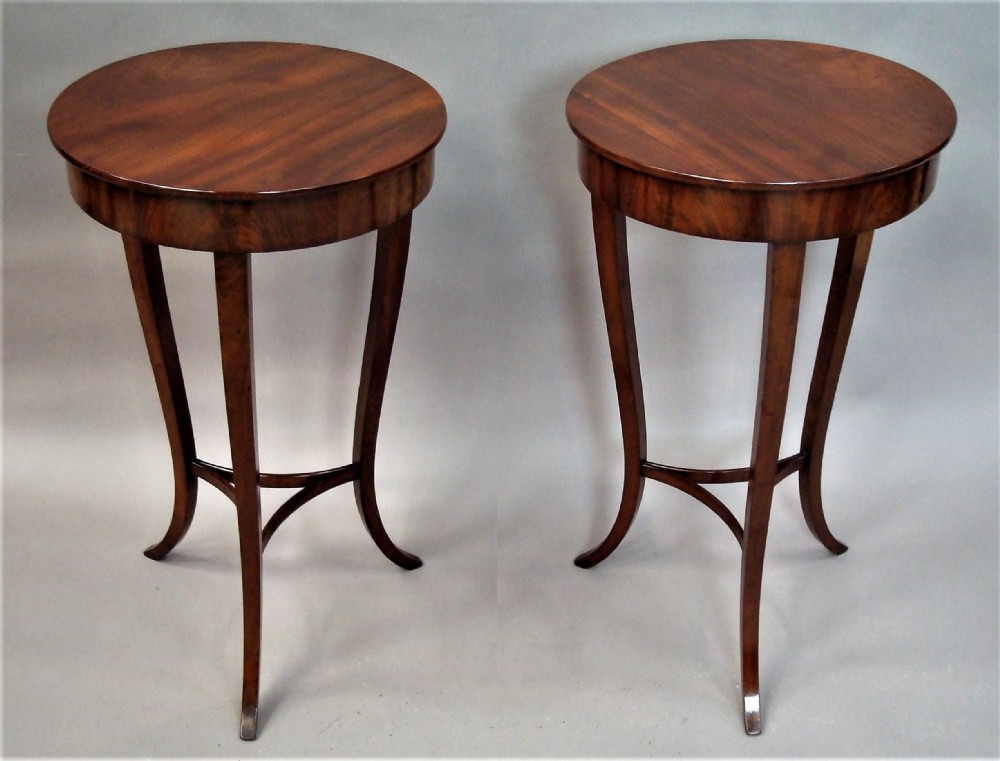A pair of matching nineteenth-century round mahogany occasional tables featuring shaped legs and circular tops against a neutral background.