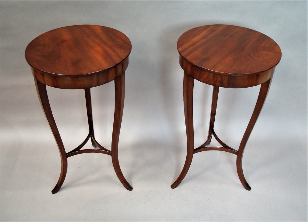 A pair of matching nineteenth-century round mahogany occasional tables featuring shaped legs and circular tops against a neutral background. View II