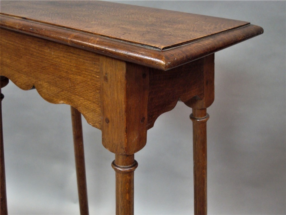 A pair of tall 19th-century oak stands featuring rectangular tops, scalloped aprons, slender turned legs, and low box stretchers. View V