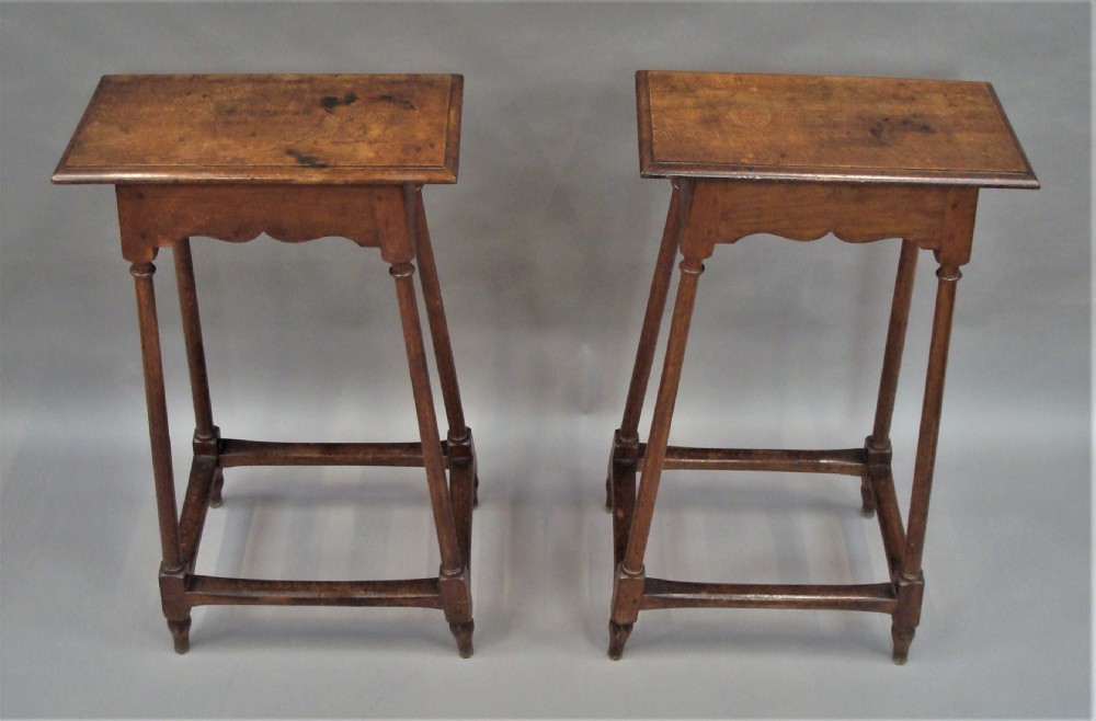 A pair of tall 19th-century oak stands featuring rectangular tops, scalloped aprons, slender turned legs, and low box stretchers. View X