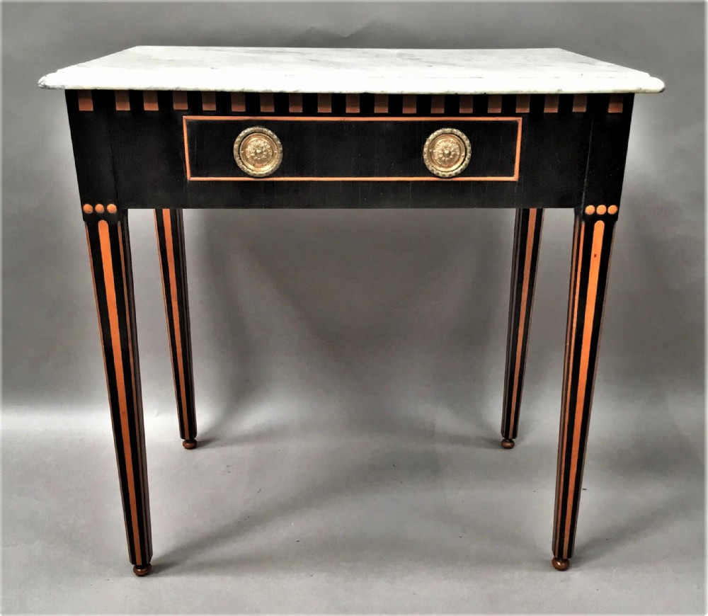 An early nineteenth-century Dutch Neoclassical side table constructed with ebonised timber, satinwood inlay, a rectangular white marble top, and tapered square legs.