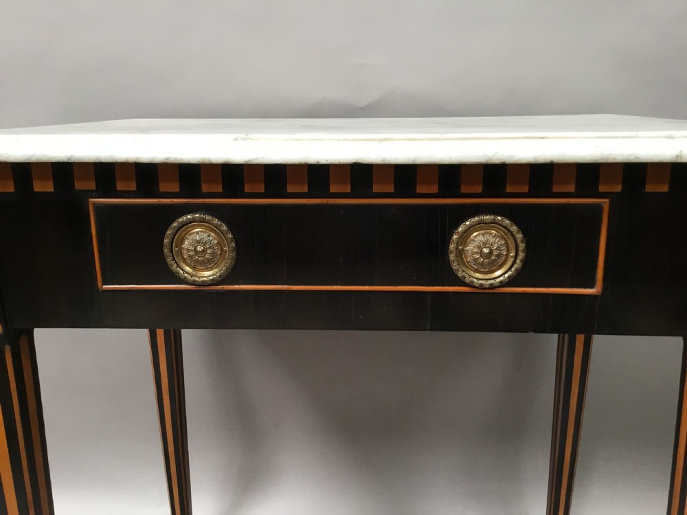 An early nineteenth-century Dutch Neoclassical side table constructed with ebonised timber, satinwood inlay, a rectangular white marble top, and tapered square legs. View VII