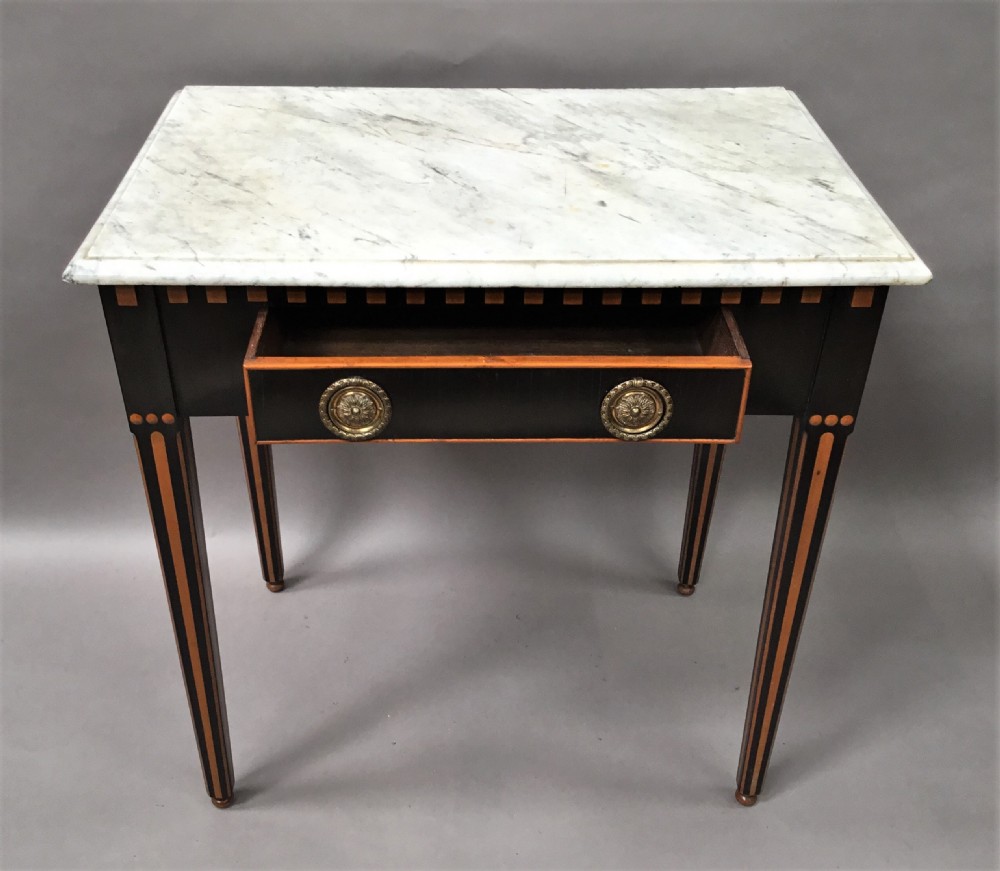 An early nineteenth-century Dutch Neoclassical side table constructed with ebonised timber, satinwood inlay, a rectangular white marble top, and tapered square legs. View IX