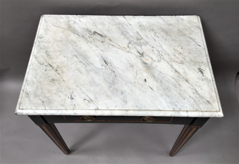 An early nineteenth-century Dutch Neoclassical side table constructed with ebonised timber, satinwood inlay, a rectangular white marble top, and tapered square legs. View XII