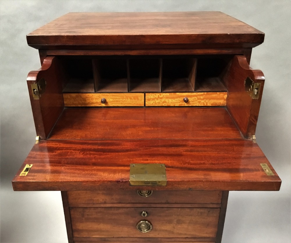 An antique Regency mahogany secretaire chest of drawers with brass ring handles and a solid plinth base. View X