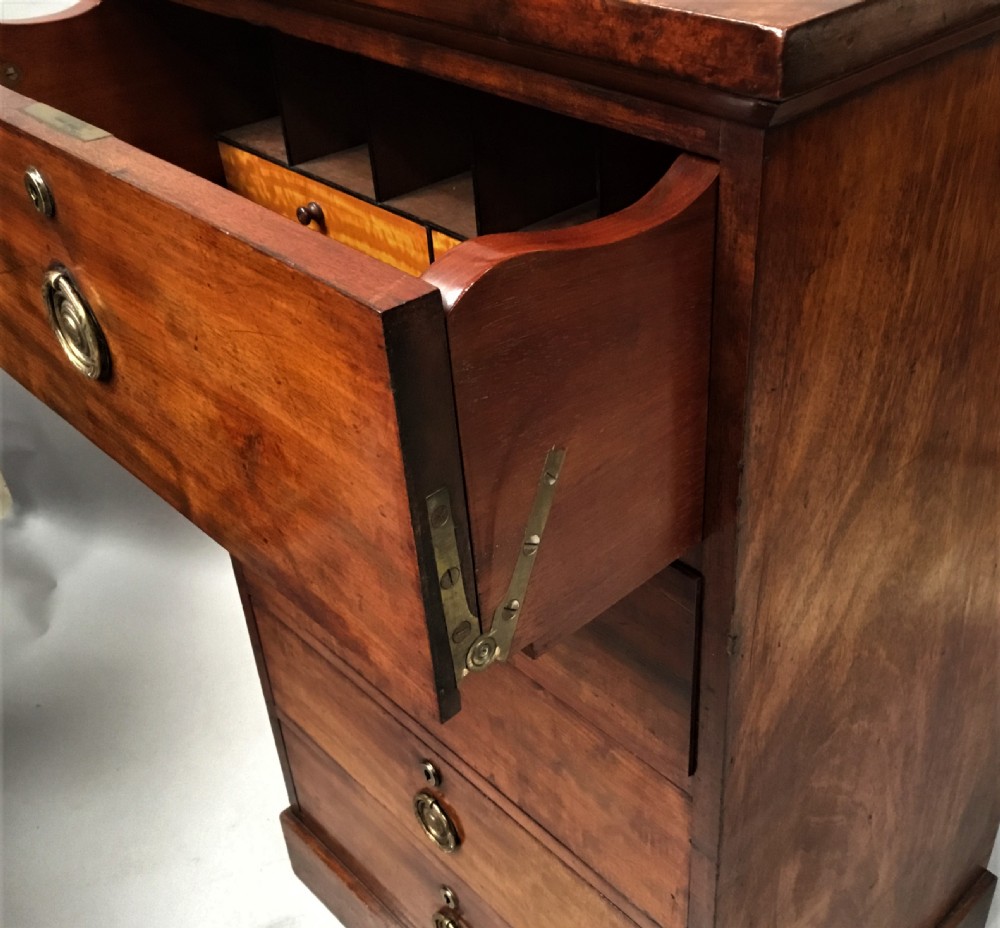 An antique Regency mahogany secretaire chest of drawers with brass ring handles and a solid plinth base. View XVI
