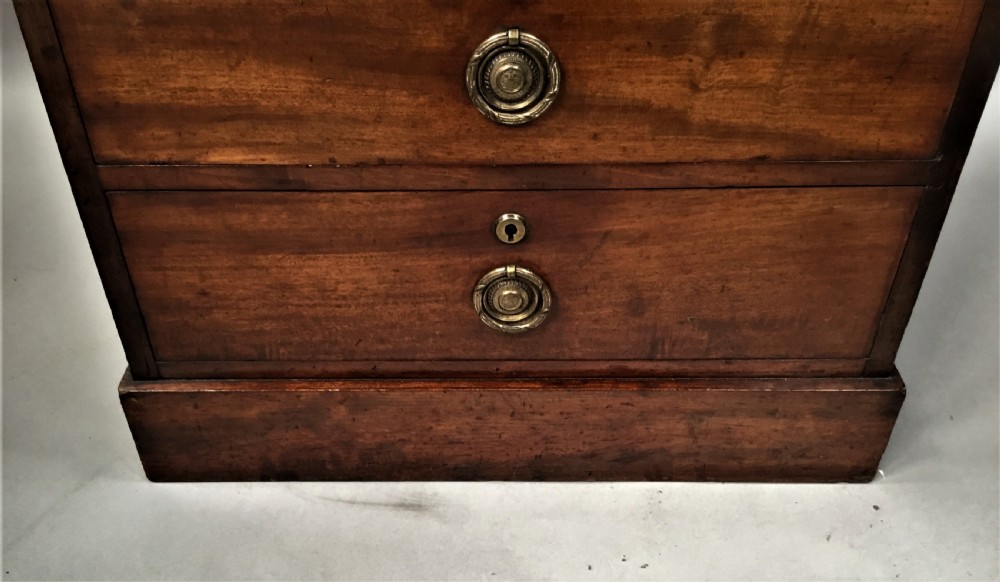 An antique Regency mahogany secretaire chest of drawers with brass ring handles and a solid plinth base. View XVII