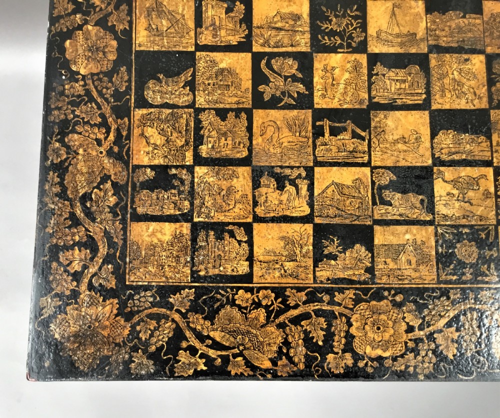A square black Regency occasional table with an inlaid chessboard top and detailed floral penwork patterns along the frieze and straight legs. View X