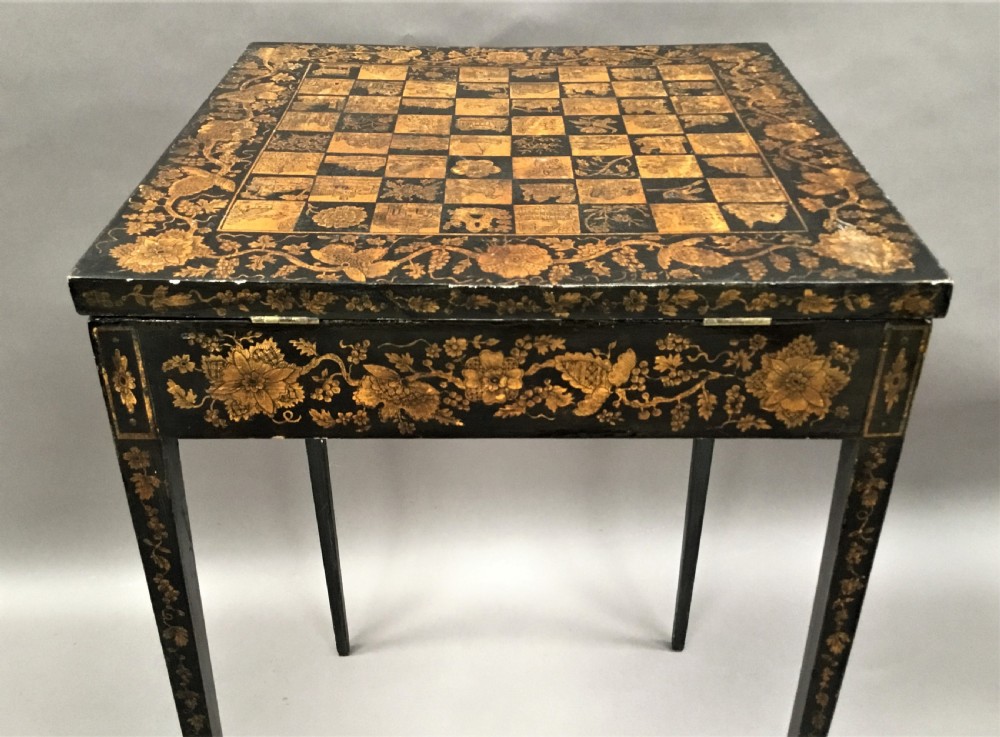 A square black Regency occasional table with an inlaid chessboard top and detailed floral penwork patterns along the frieze and straight legs. View XVI