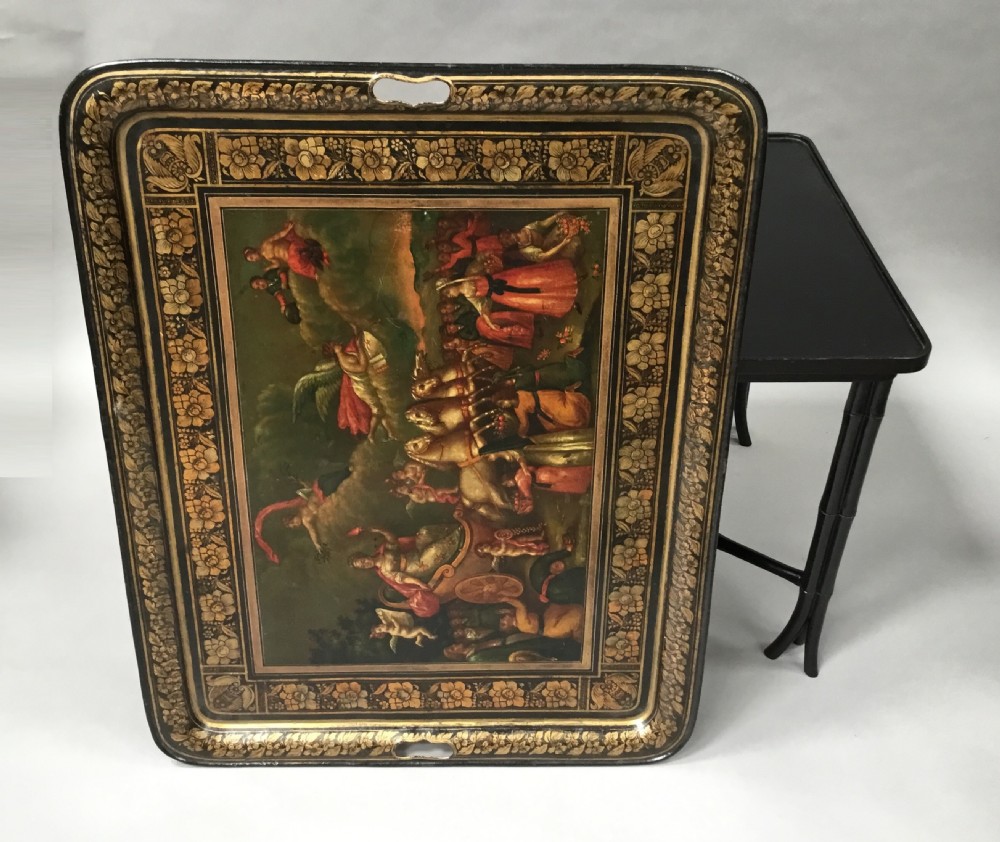 A large Regency painted toleware tray featuring a classical mythological scene and gilded borders, mounted on a black faux bamboo cross-leg stand. View XI