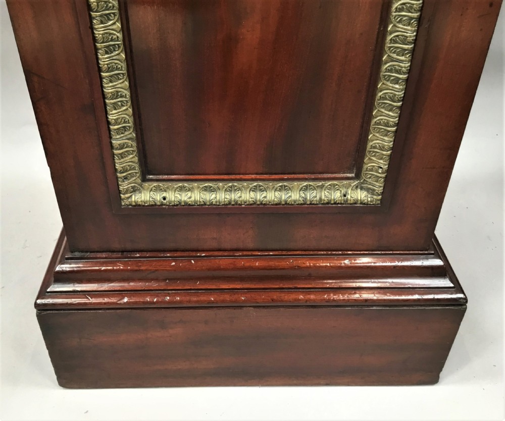 A tall mahogany Regency pedestal cabinet featuring cast brass leaf borders and a single panelled door on a plinth base. View XI