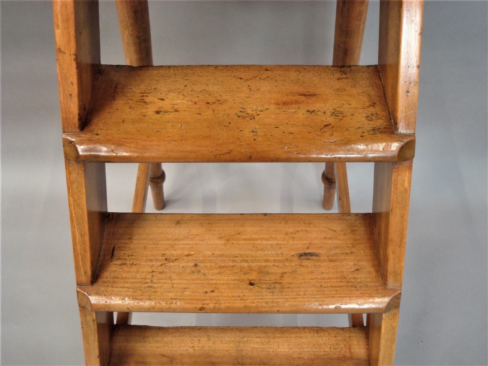 A nineteenth-century English fruitwood library ladder with four steps, a top platform, and turned back legs. View XIII