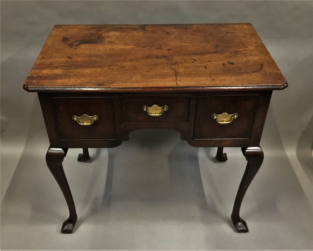 An 18th-century George II mahogany lowboy table featuring three drawers with brass drop handles, a shaped apron, and four cabriole legs with pad feet. View V