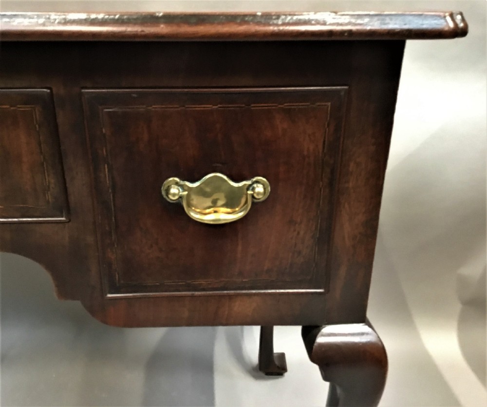 An 18th-century George II mahogany lowboy table featuring three drawers with brass drop handles, a shaped apron, and four cabriole legs with pad feet. View IX