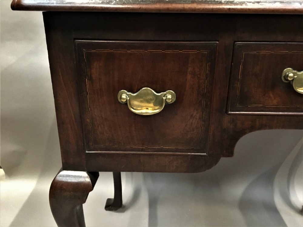 An 18th-century George II mahogany lowboy table featuring three drawers with brass drop handles, a shaped apron, and four cabriole legs with pad feet. View XI