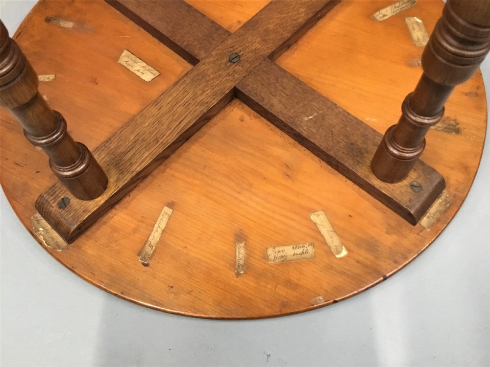 A nineteenth-century circular specimen wood side table featuring a geometric starburst inlaid tabletop supported by four turned legs and an X-frame cross stretcher. View X