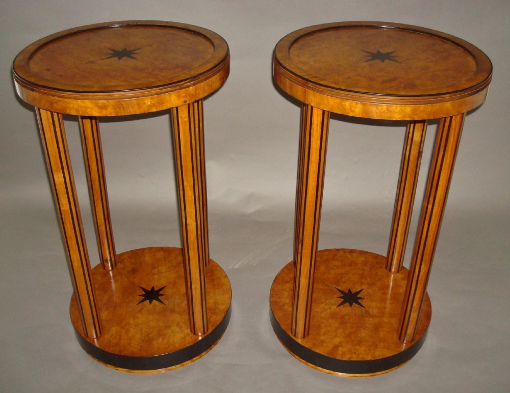 A pair of circular burr elm occasional tables featuring inlaid ebony star motifs, slender vertical legs with black stringing, and an ebony-banded lower tier. View VI