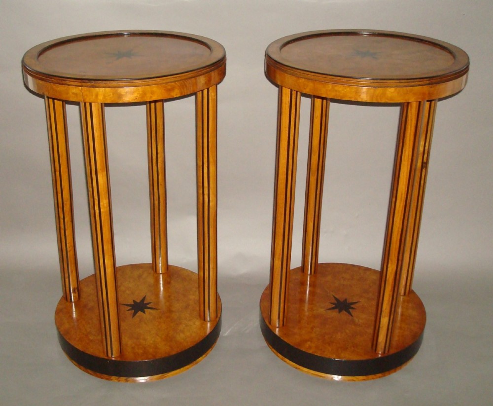 A pair of circular burr elm occasional tables featuring inlaid ebony star motifs, slender vertical legs with black stringing, and an ebony-banded lower tier. View VII