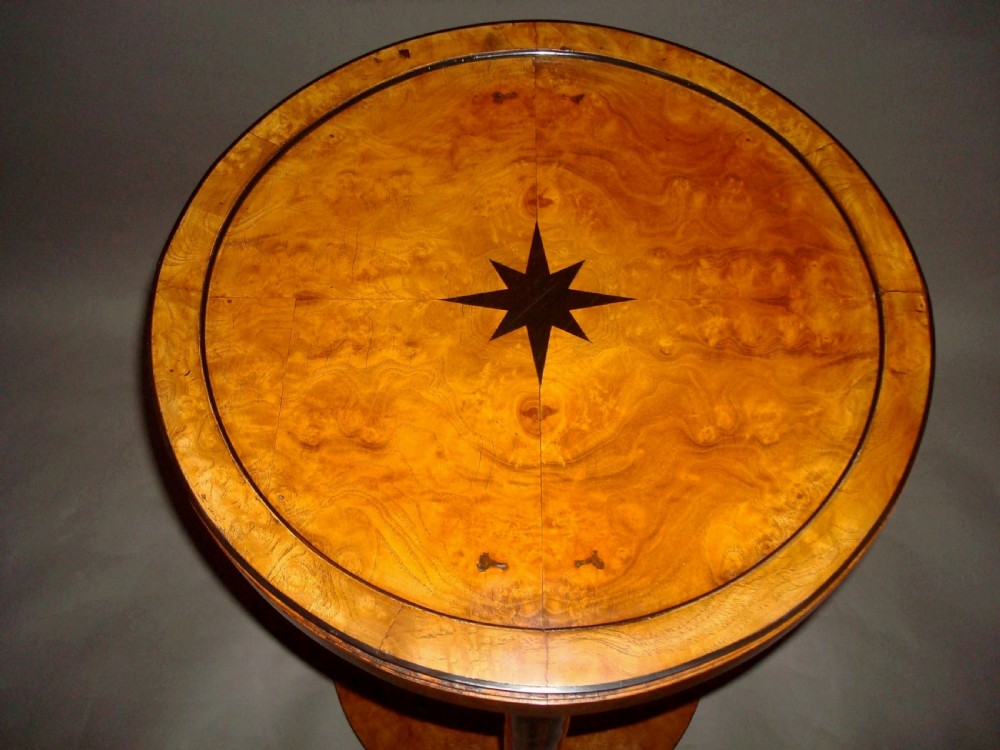 A pair of circular burr elm occasional tables featuring inlaid ebony star motifs, slender vertical legs with black stringing, and an ebony-banded lower tier. View X