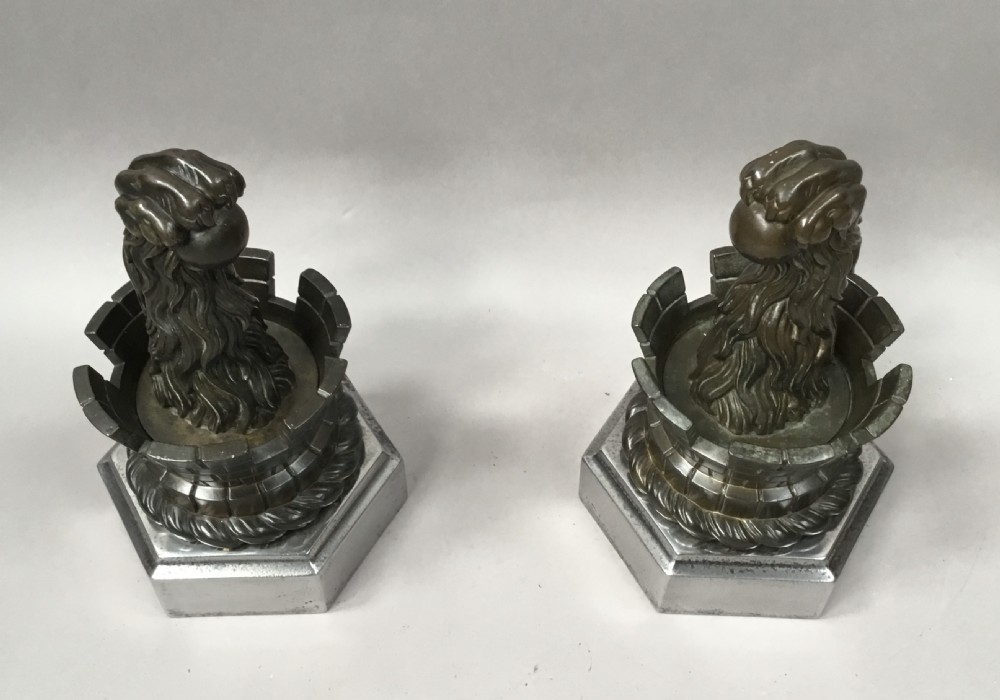 A pair of nineteenth-century bronze door stops featuring a heraldic lion paw holding a ball above a castellated wall, resting on heavy hexagonal bases. View VIII
