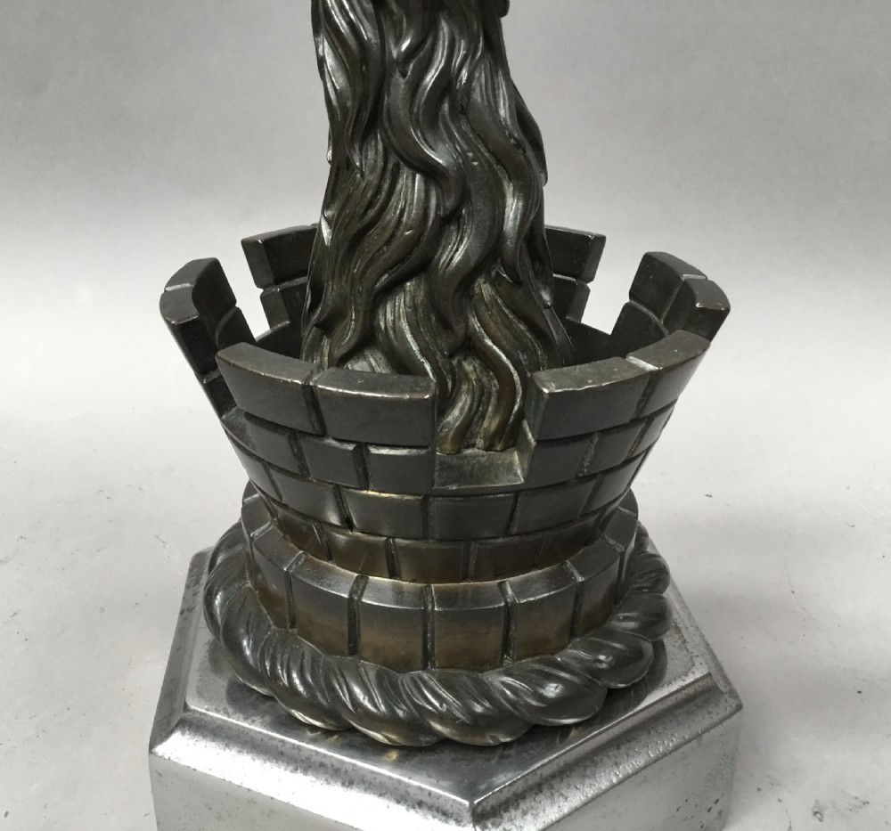 A pair of nineteenth-century bronze door stops featuring a heraldic lion paw holding a ball above a castellated wall, resting on heavy hexagonal bases. View XIV