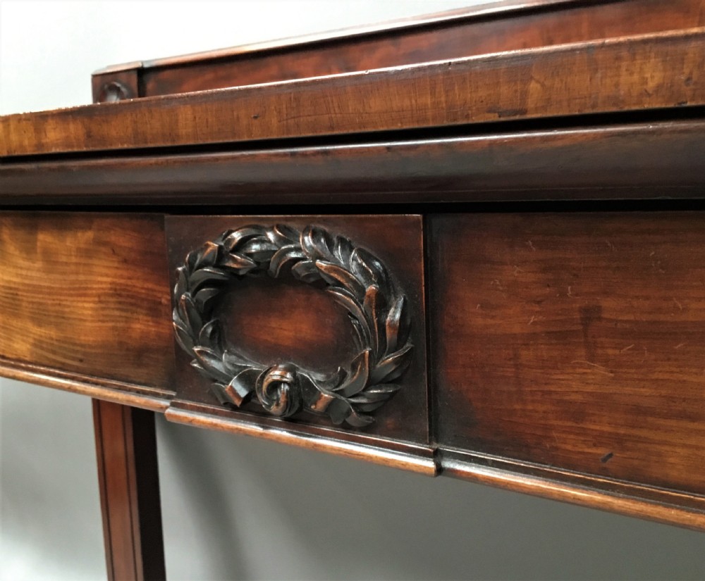 A Regency mahogany side serving table featuring a low upstand with carved rosettes, fluted square tapered legs with ionic capitals, and a flame mahogany apron. View IV