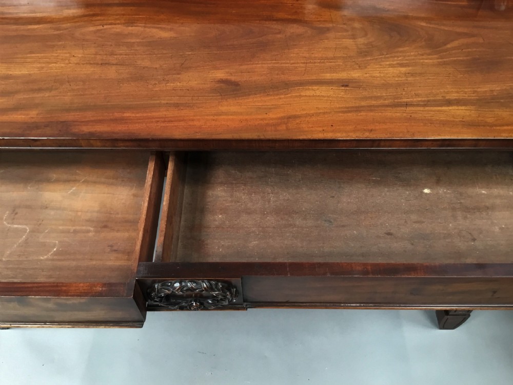 A Regency mahogany side serving table featuring a low upstand with carved rosettes, fluted square tapered legs with ionic capitals, and a flame mahogany apron. View VII