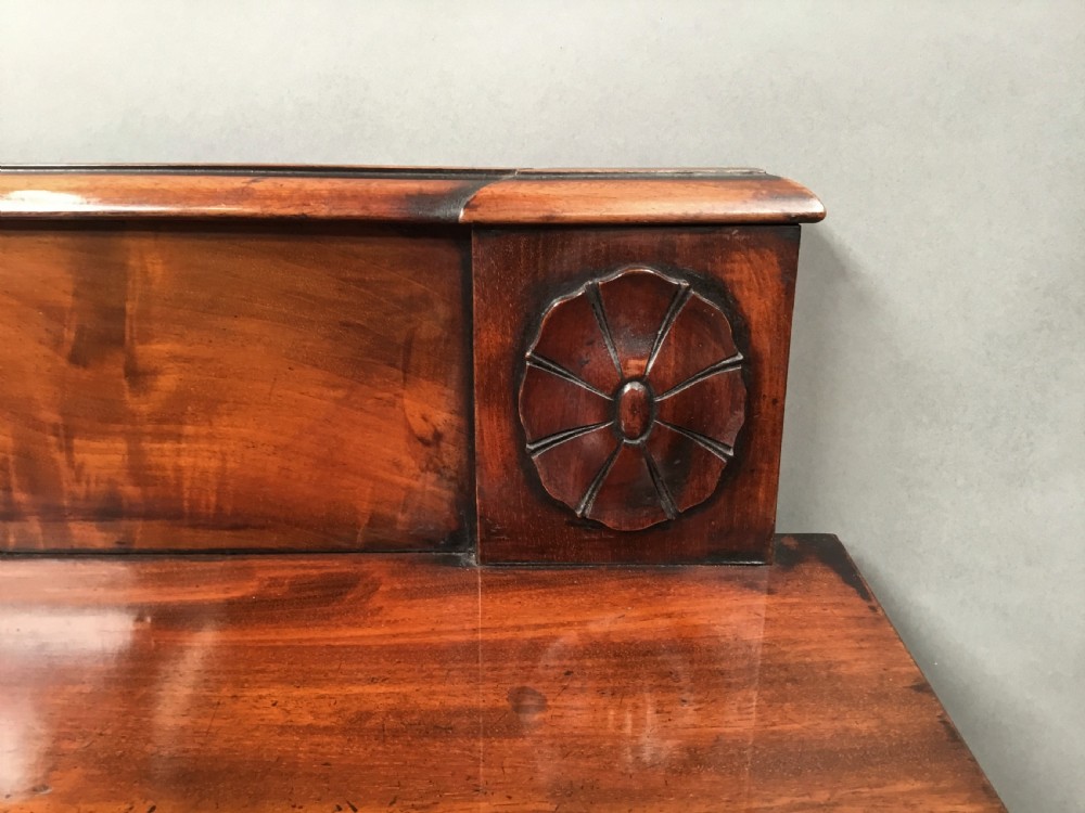 A Regency mahogany side serving table featuring a low upstand with carved rosettes, fluted square tapered legs with ionic capitals, and a flame mahogany apron. View XI