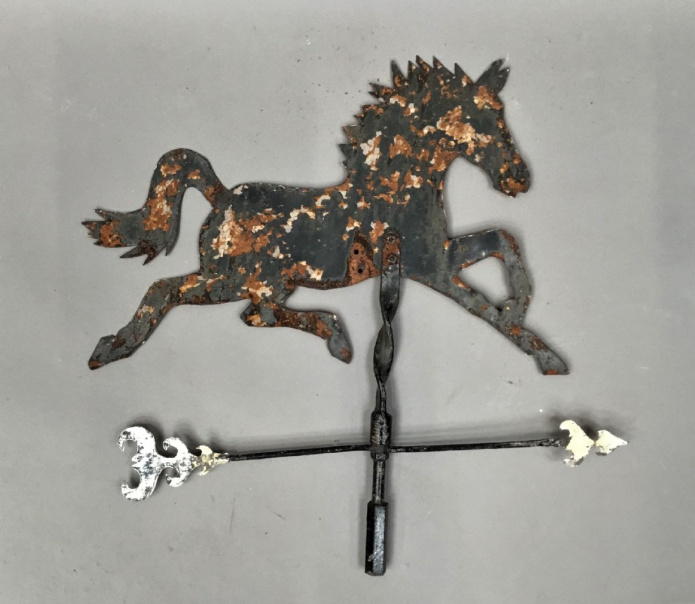 A nineteenth-century black iron horse silhouette weathervane with trace gold leaf detailing, mounted on a central spindle above a directional arrow. View V