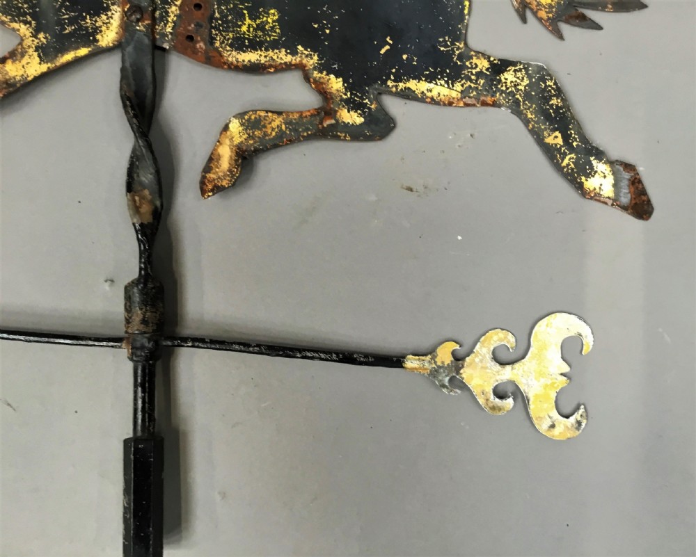 A nineteenth-century black iron horse silhouette weathervane with trace gold leaf detailing, mounted on a central spindle above a directional arrow. View VI