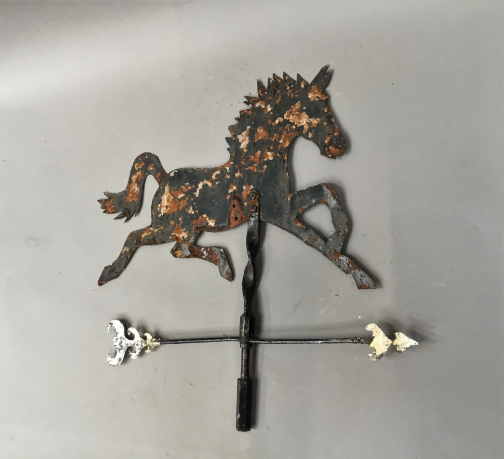 A nineteenth-century black iron horse silhouette weathervane with trace gold leaf detailing, mounted on a central spindle above a directional arrow. View VIII