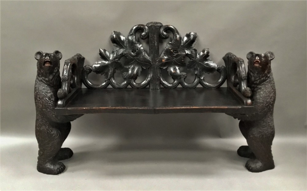 A 19th-century dark carved wood hall seat supported by two sculptural standing bear figures with a carved leaf motif backrest. View II