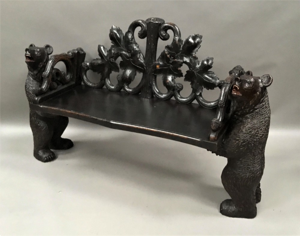 A 19th-century dark carved wood hall seat supported by two sculptural standing bear figures with a carved leaf motif backrest. View V