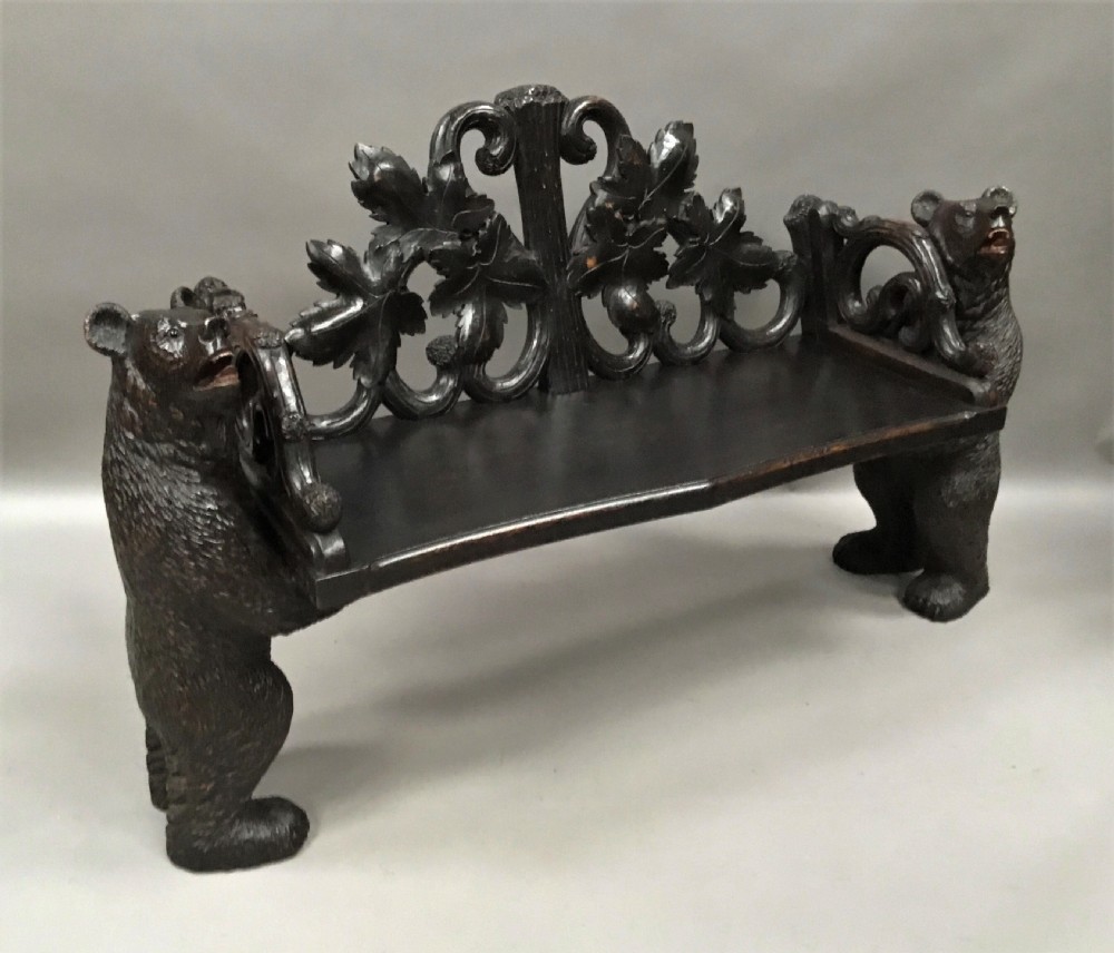 A 19th-century dark carved wood hall seat supported by two sculptural standing bear figures with a carved leaf motif backrest. View VII