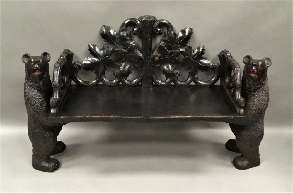 A 19th-century dark carved wood hall seat supported by two sculptural standing bear figures with a carved leaf motif backrest. View IX