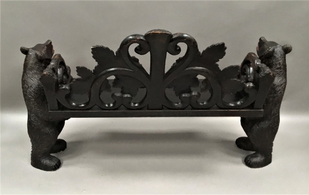A 19th-century dark carved wood hall seat supported by two sculptural standing bear figures with a carved leaf motif backrest. View XX