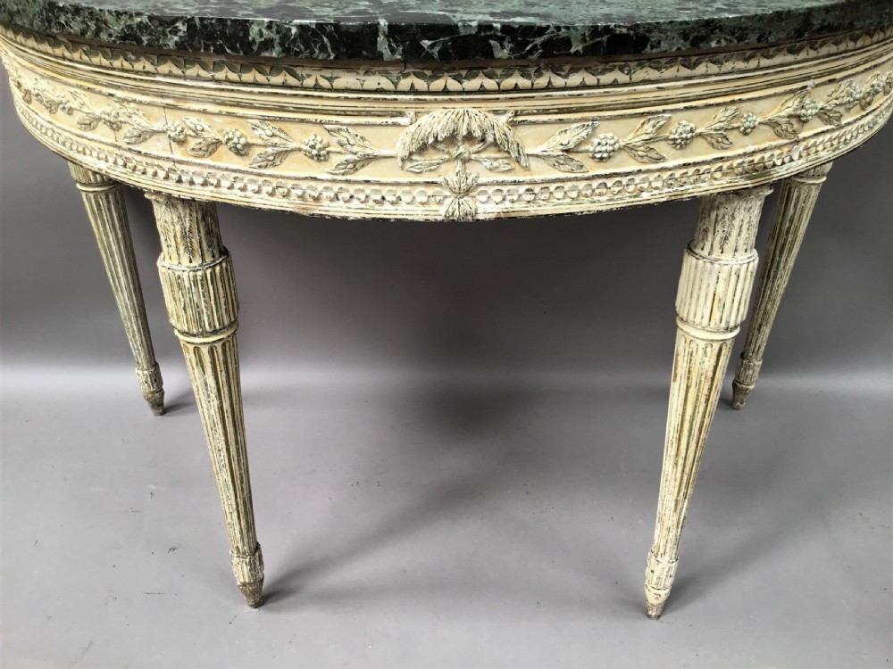 An 18th-century Italian Neoclassical demilune console table featuring an off-white painted timber frame with fluted tapered legs and a dark green marble top. View II