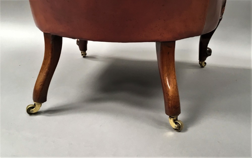 A pair of Victorian mahogany armchairs upholstered in button-backed deep red leather featuring scrolled arms and front cabriole legs on brass castors. View XIV