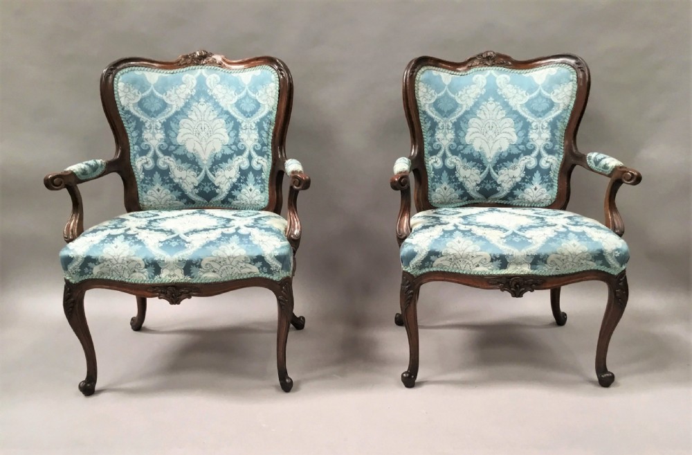 A pair of 18th-century Italian open armchairs featuring carved walnut frames, cabriole legs, and light blue damask pattern upholstery. View II