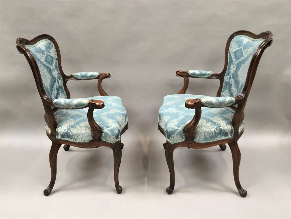 A pair of 18th-century Italian open armchairs featuring carved walnut frames, cabriole legs, and light blue damask pattern upholstery. View III