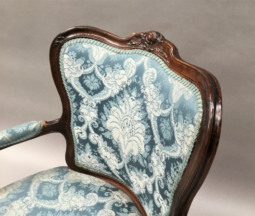 A pair of 18th-century Italian open armchairs featuring carved walnut frames, cabriole legs, and light blue damask pattern upholstery. View VII