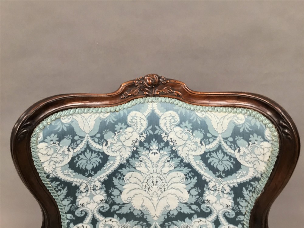 A pair of 18th-century Italian open armchairs featuring carved walnut frames, cabriole legs, and light blue damask pattern upholstery. View XVII