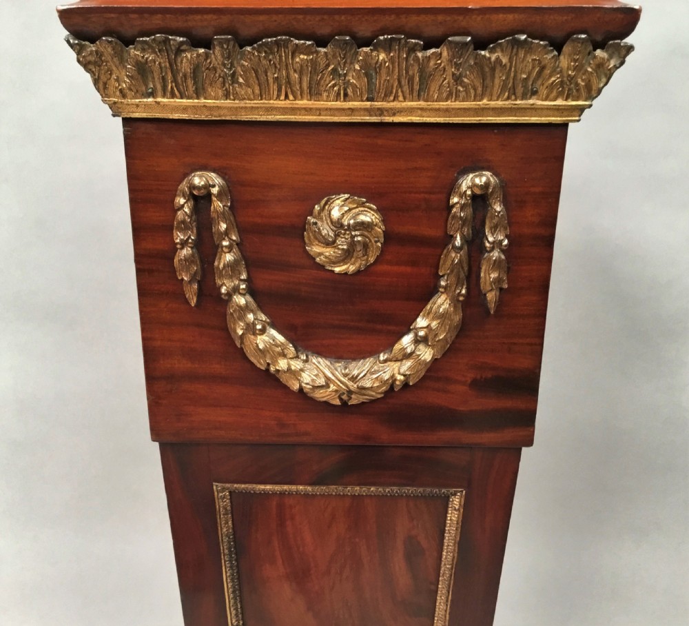A 19th-century tapered mahogany pedestal featuring decorative gilt bronze swags, rosettes, and a moulded base. View IV