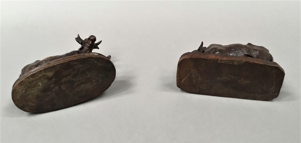 A pair of late nineteenth-century carved dark wood cows mounted on integrated plinths, showing textured coats and bells carved around their necks. View XIII