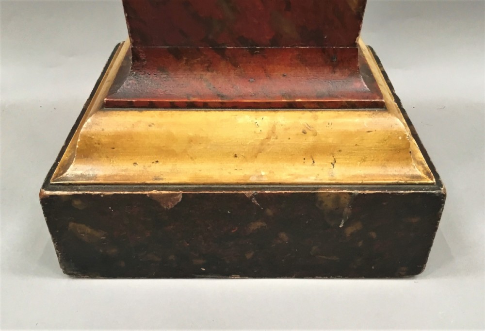A tall tapering wooden display pedestal with a red faux-marble painted finish and gilded stepped mouldings at the top and base. View XII